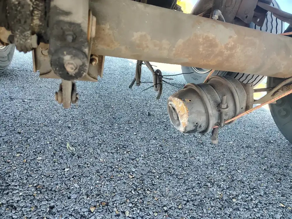 Exposed axle and brake assembly beneath a vehicle